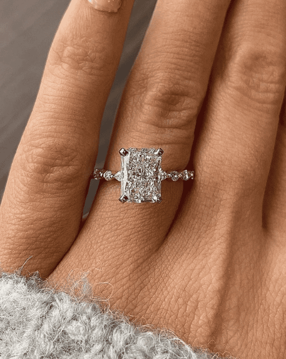 A person shows off a classic Winter Jewelry engagement ring, highlighting beauty and elegance in a cozy, relaxed look.