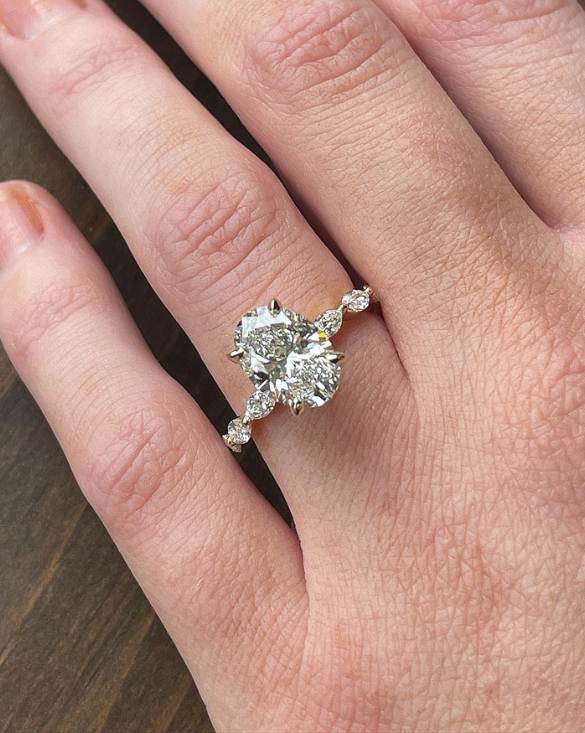 A hand shows off a Winter Jewelry ring with two big natural diamonds, sparkling and unique, showing fine detail and beauty.