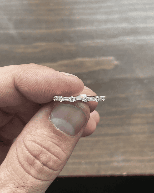 A hand shows a shiny gold ring with sparkling stones from Winter Jewelry, highlighting its simple and elegant style.