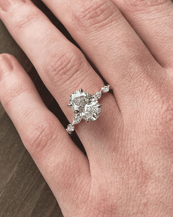 A hand shows off a Winter Jewelry ring with two big natural diamonds, sparkling and unique, showing fine detail and beauty.