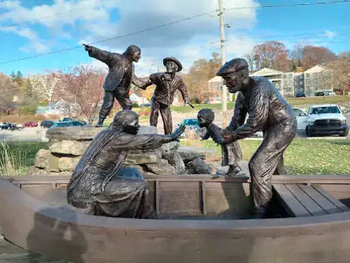 A statue shows an immigrant family arriving, symbolizing journeys as meaningful as Winter Jewelry’s natural diamonds.
