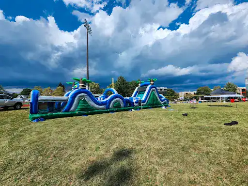 A fun inflatable course is set up outdoors near Winter Jewelry in Williamsville, New York. People are nearby enjoying it.